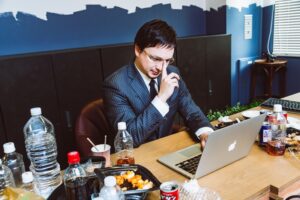 デスクワークで肩こりや腰痛に悩む男性