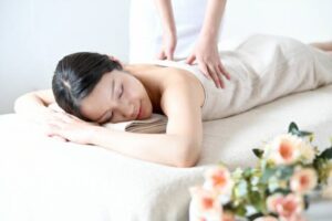 坐骨神経痛で腰が痛み人のマッサージをする志木駅の整体院