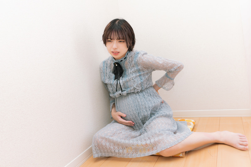 椎間板ヘルニアで腰が痛く動けない女性