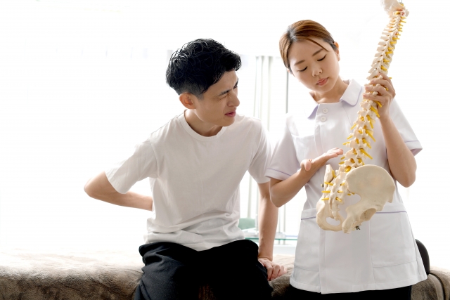 接骨院で腰痛の説明を受ける男性