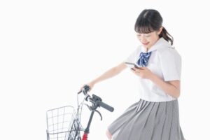 スマホを操作しながら自転車を運転する学生