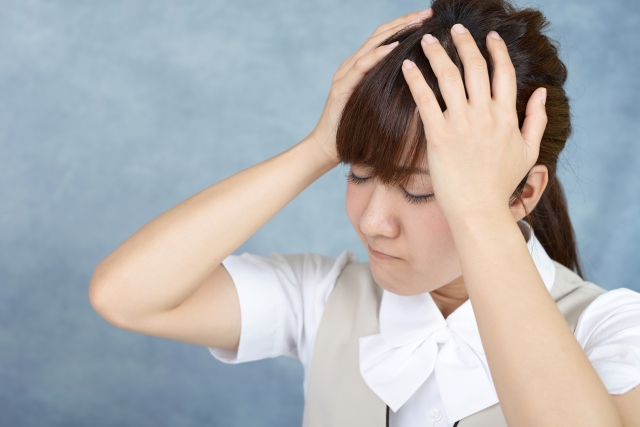 頭痛による痛みで悩む女性