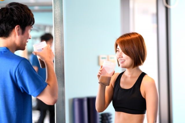 トレーニング後にプロテインを飲む男女